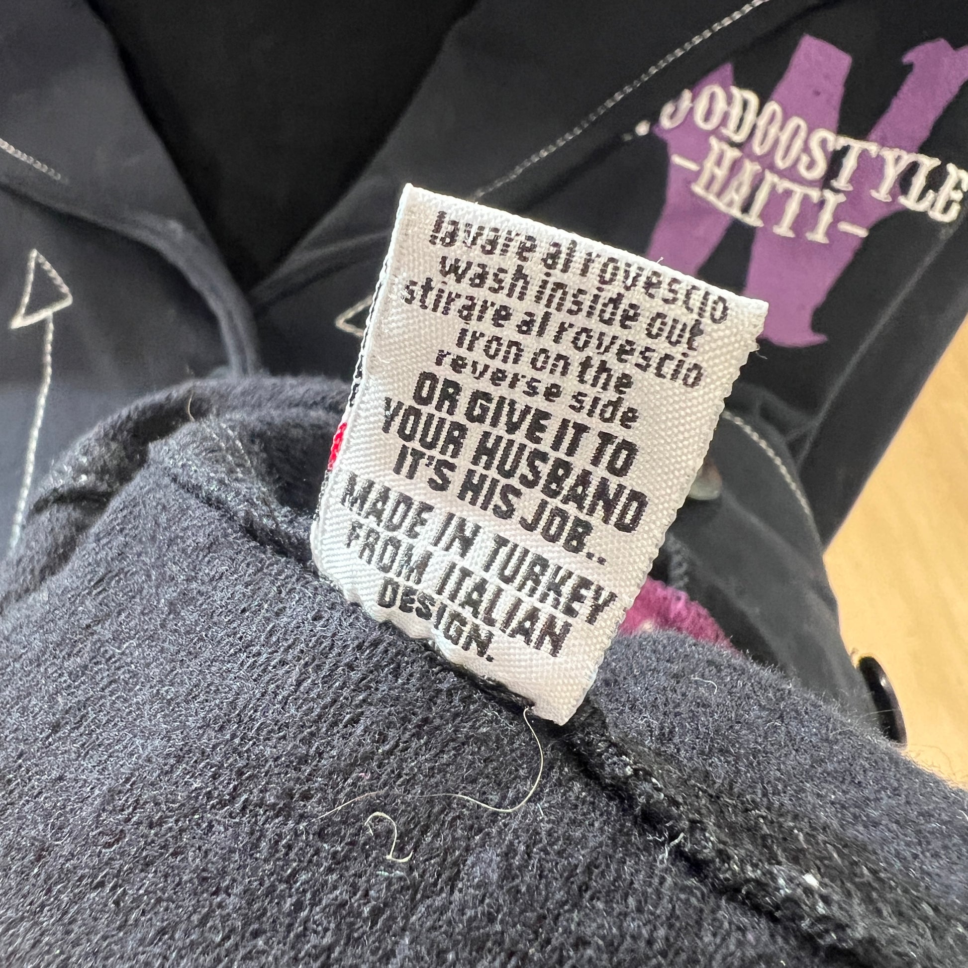 Clothing label on a garment with text and branding visible