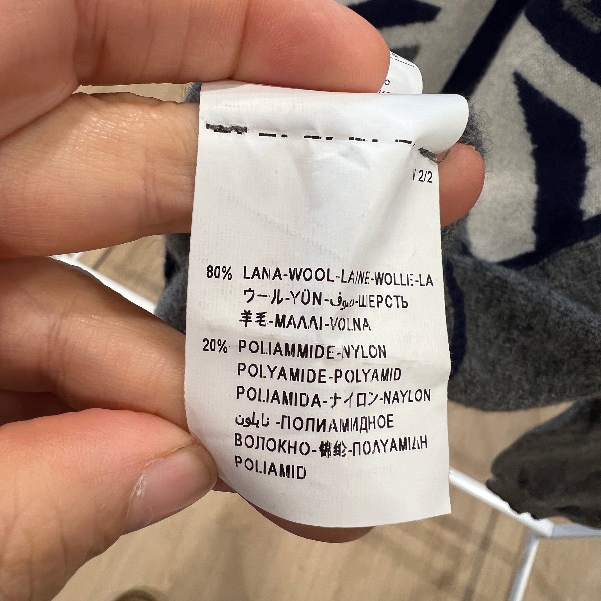 Clothing label with material composition details held by a hand