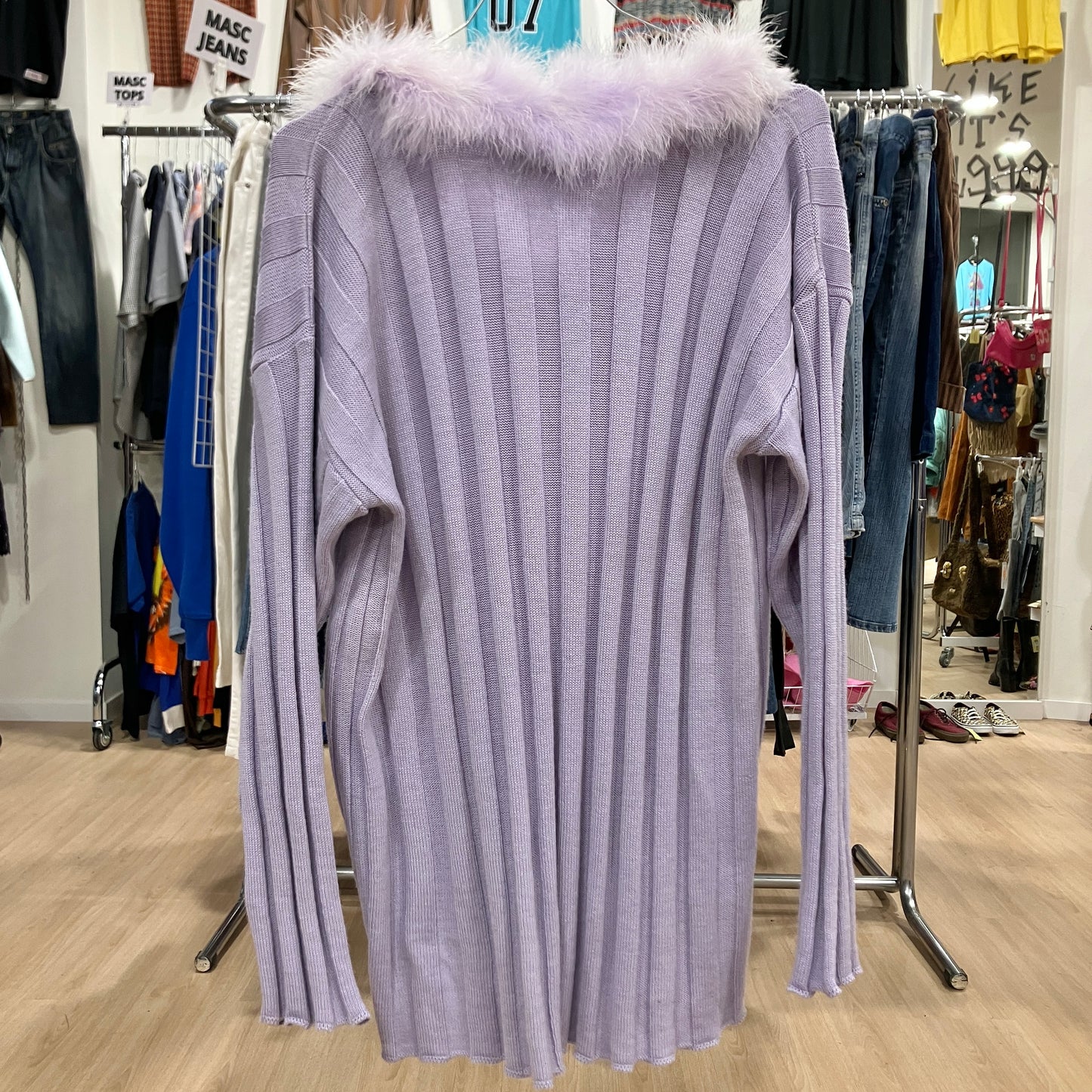 Light purple ribbed sweater with fur collar on a rack in a store setting