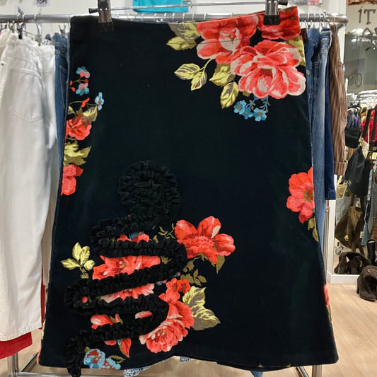 Black dress with colorful floral embroidery on a rack in a store