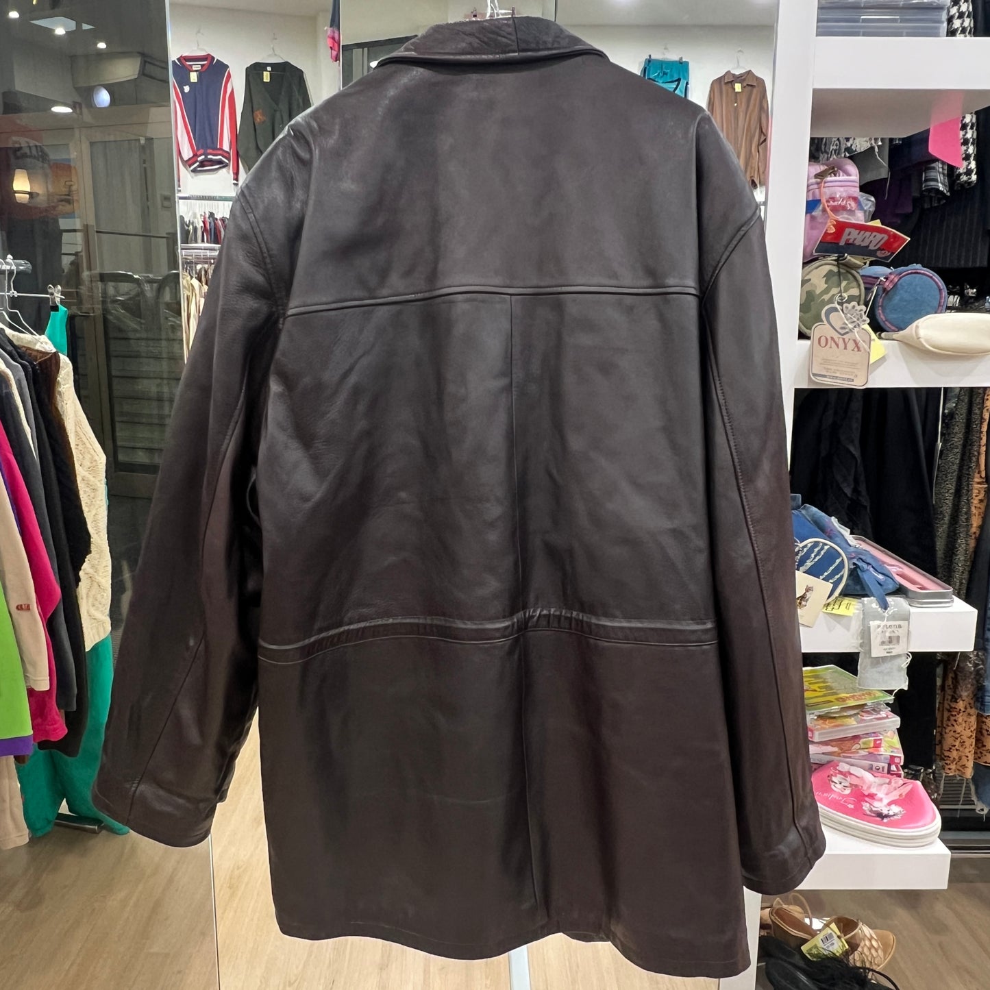 Brown leather jacket on a mannequin in a store setting