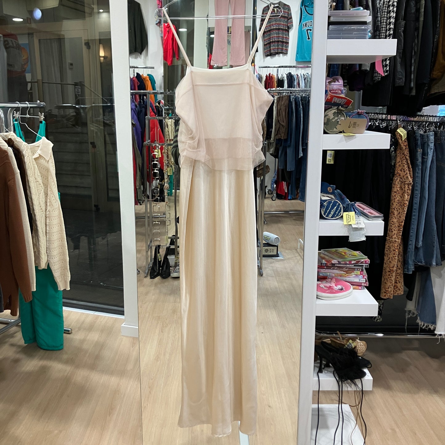 Beige dress in a clothing store with racks and shelves in the background