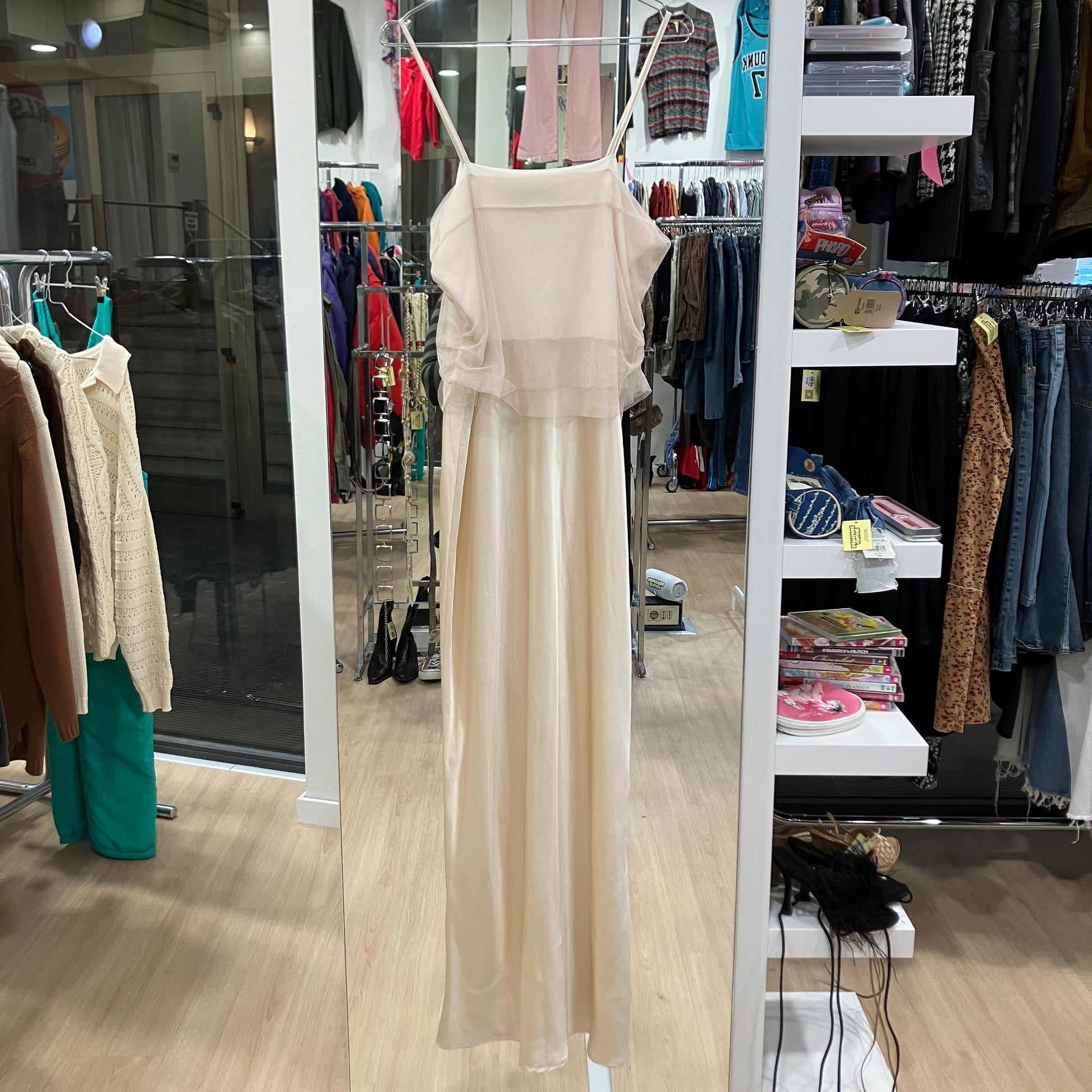 Beige dress in a clothing store with racks and shelves in the background