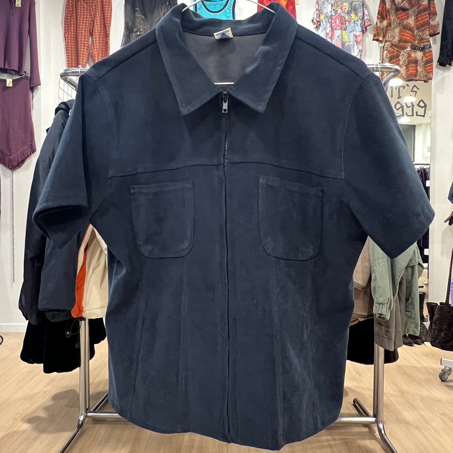 Navy blue jacket on a hanger in a clothing store
