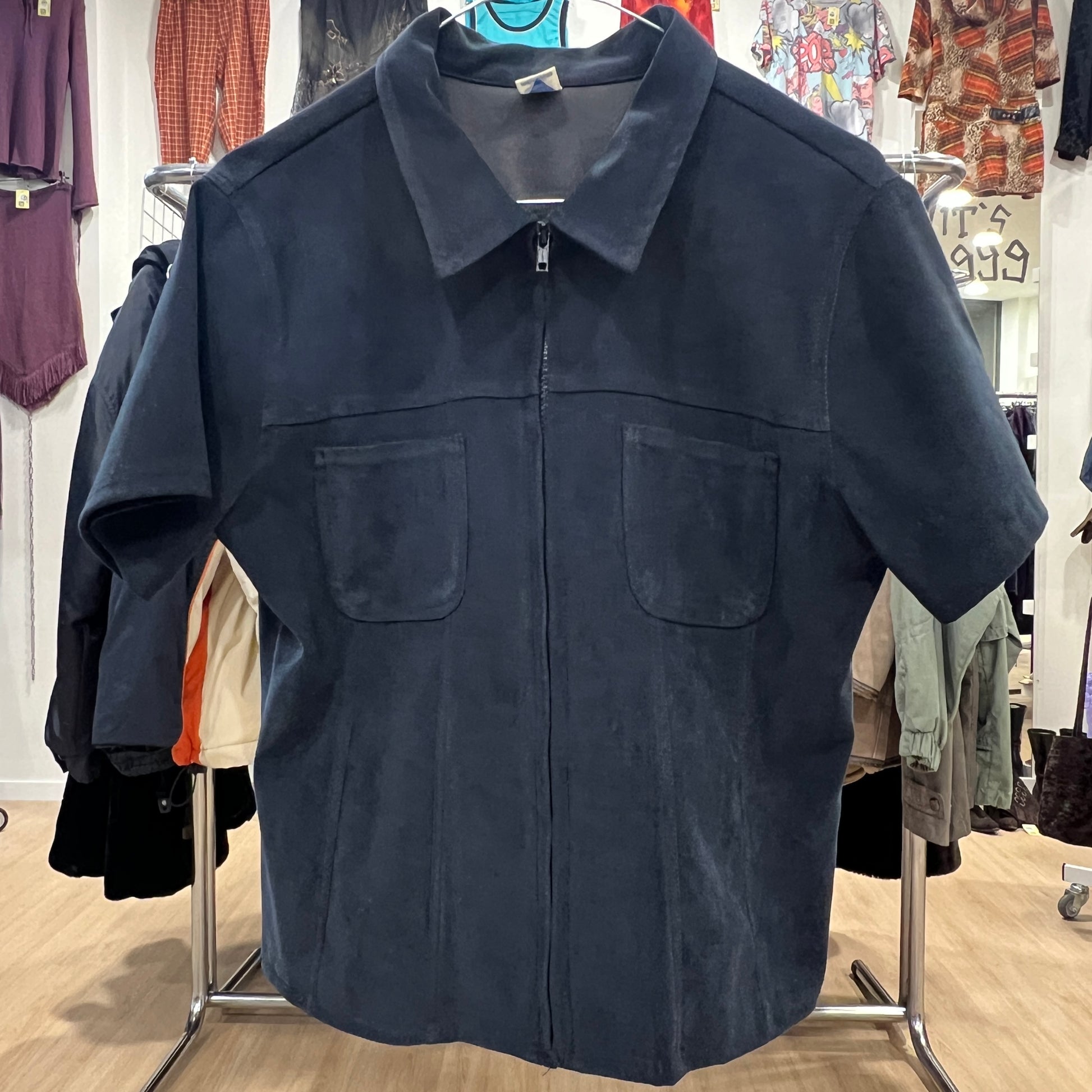 Navy blue jacket on a hanger in a clothing store