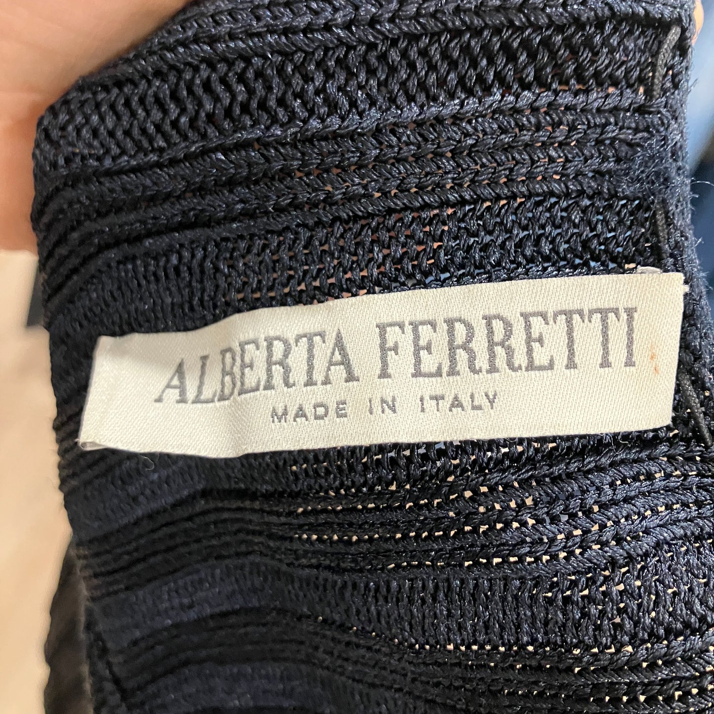 Close-up of Alberta Ferretti label on a textured fabric background