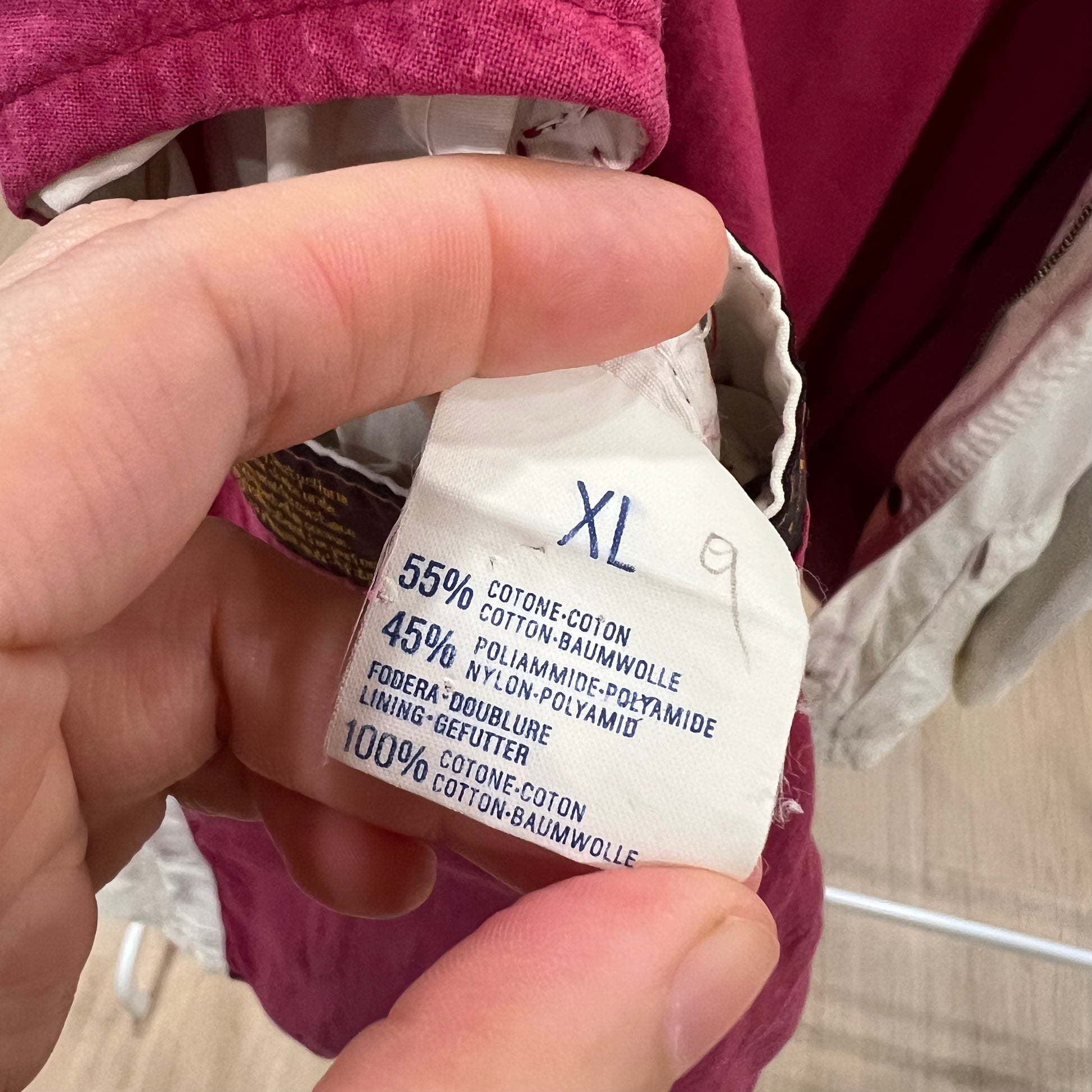 Close-up of a clothing label with size 'XL' and material information