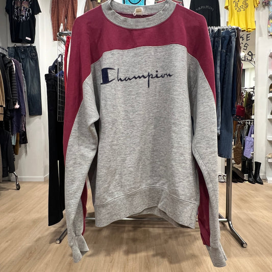 Gray and red Champion sweatshirt on a rack in a store setting