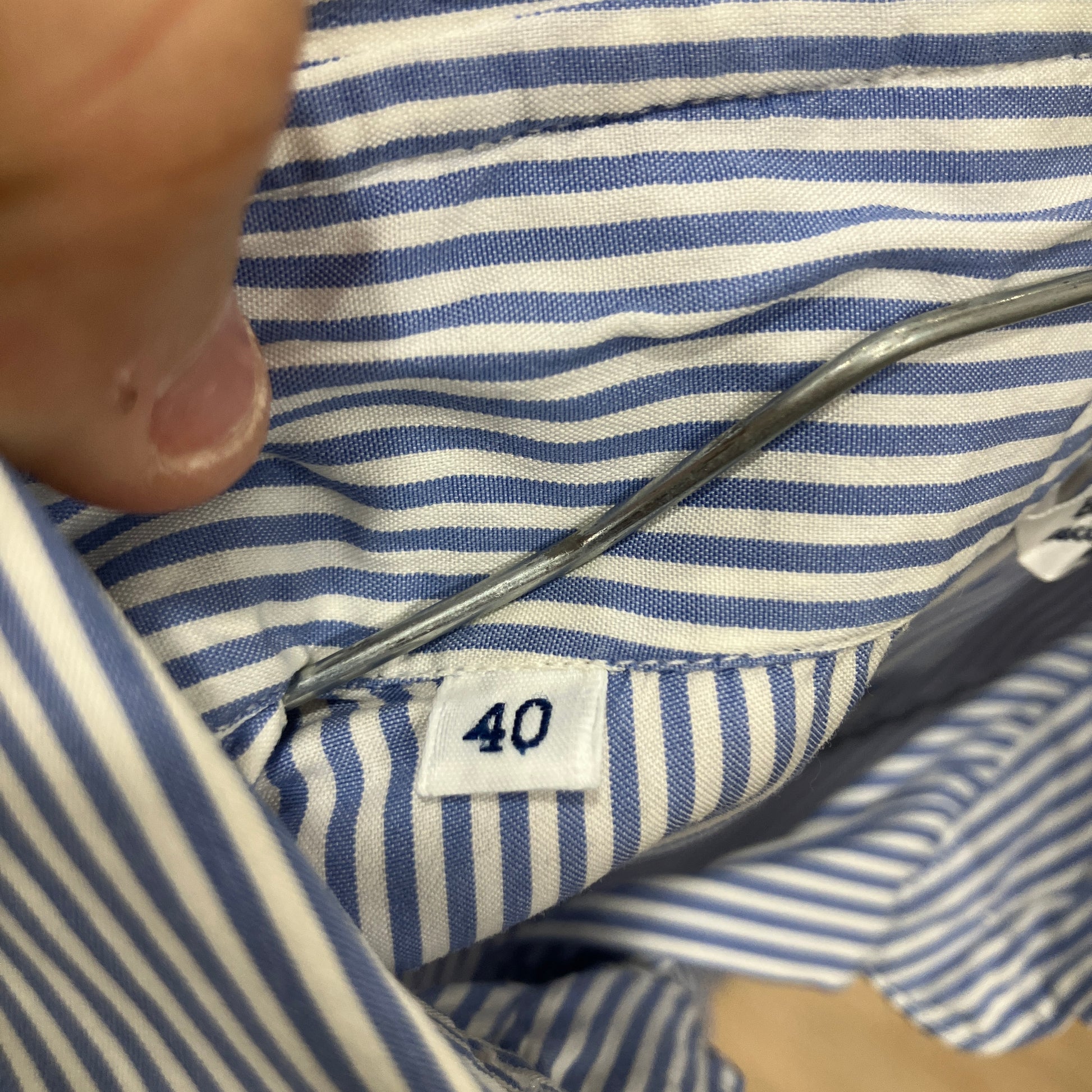 Close-up of a blue and white striped shirt with a size tag showing '40'