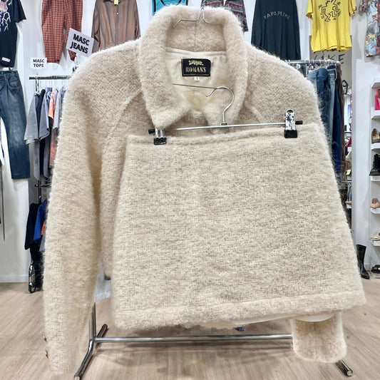 Beige fleece jacket on a hanger with a store background