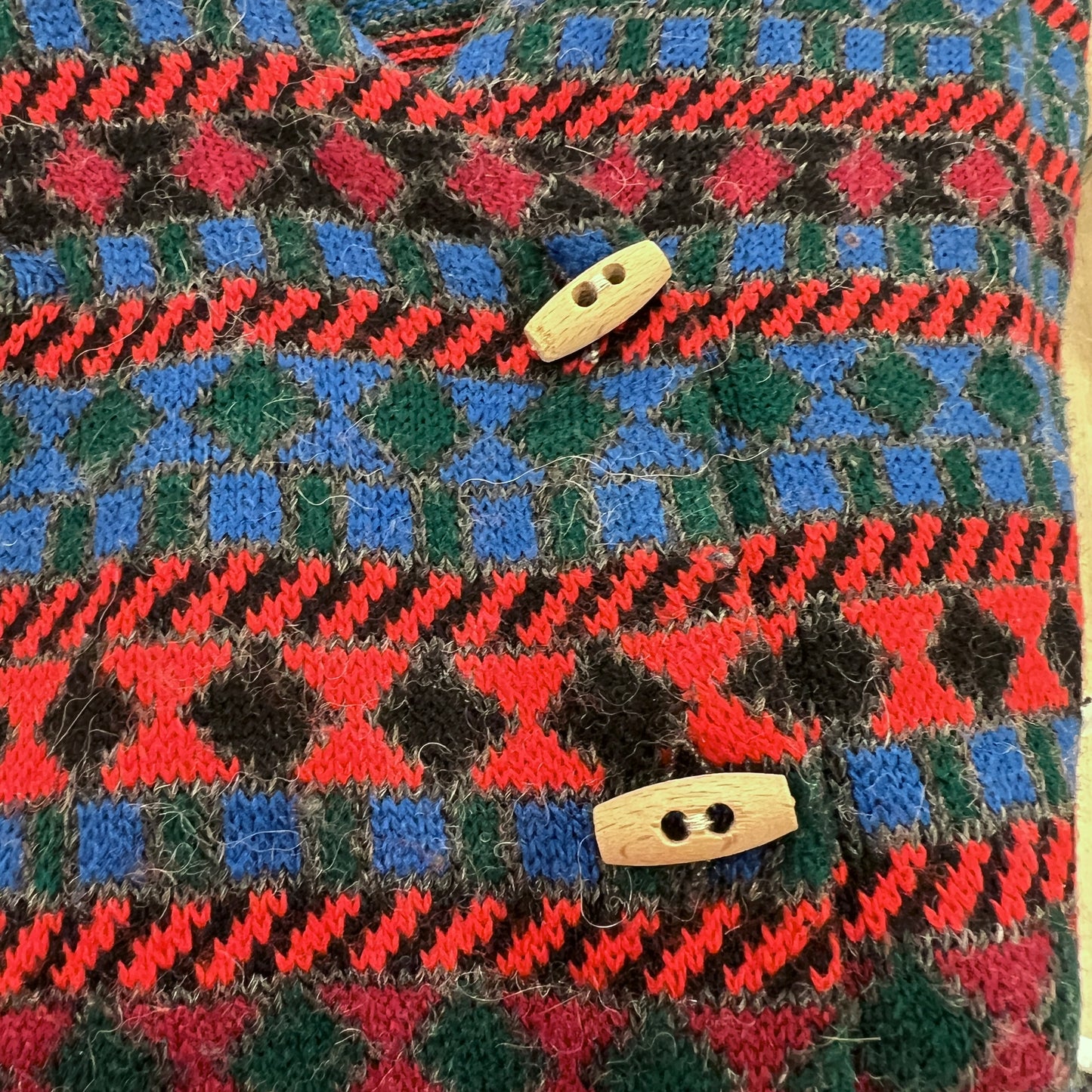 Close-up of a textured fabric with a pattern and wooden buttons