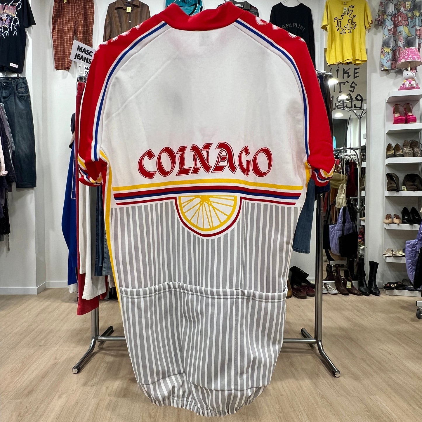 Vintage-style sports jacket with 'Colnago' branding in a store setting