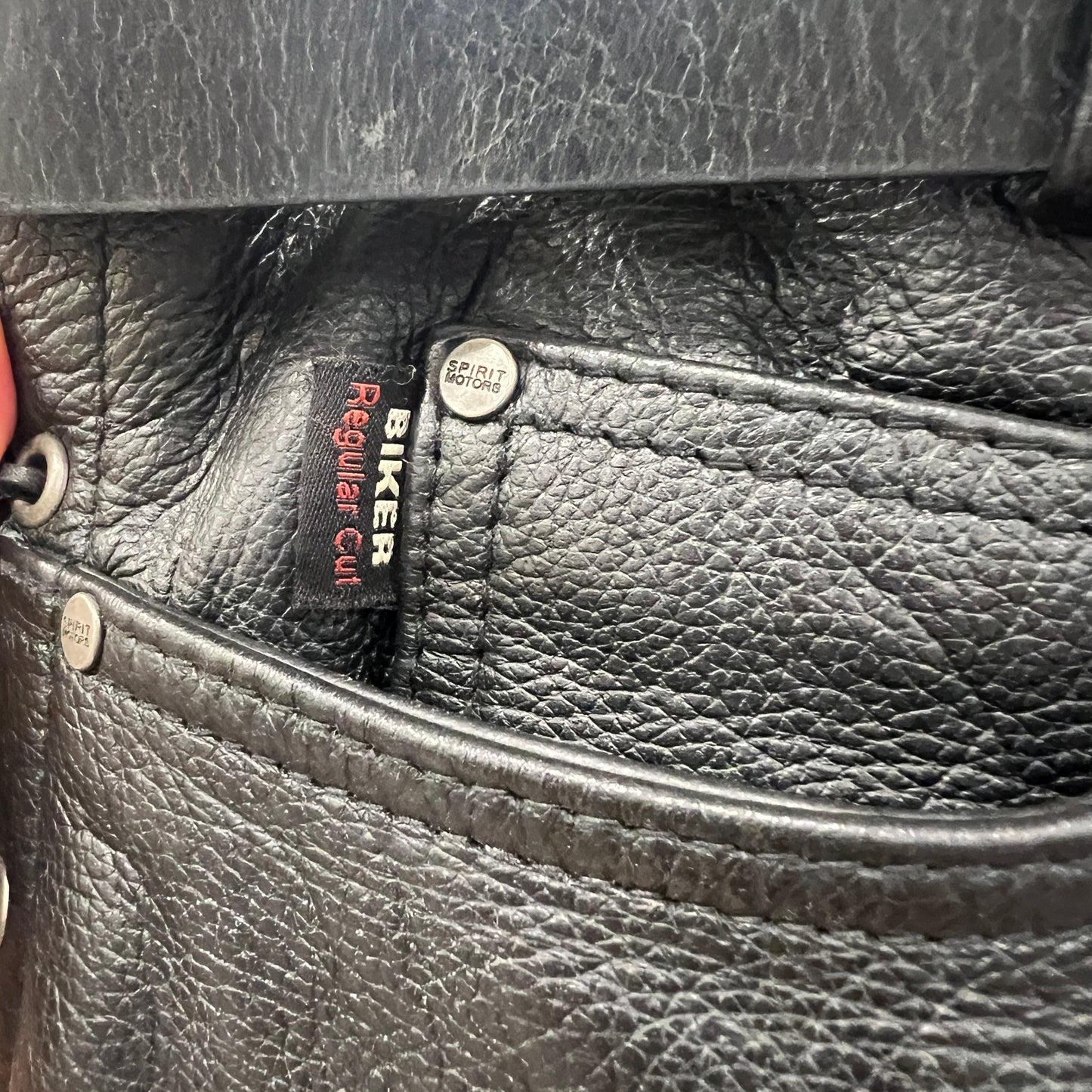 Close-up of a black leather bag with visible branding and stitching details