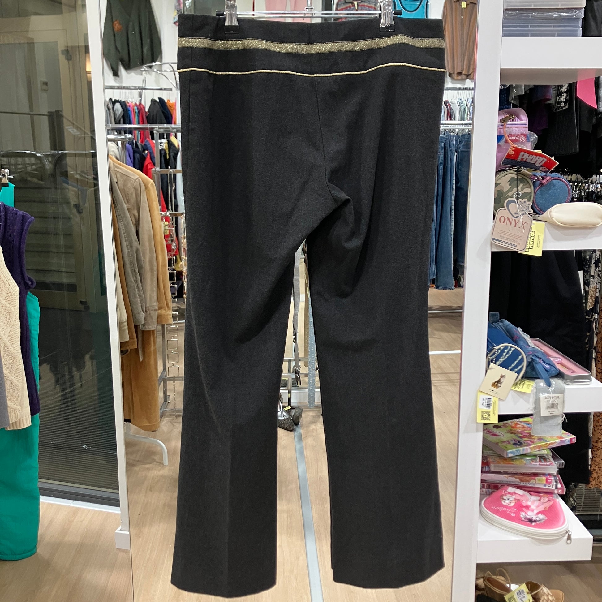 Black pants hanging on a rack in a store setting