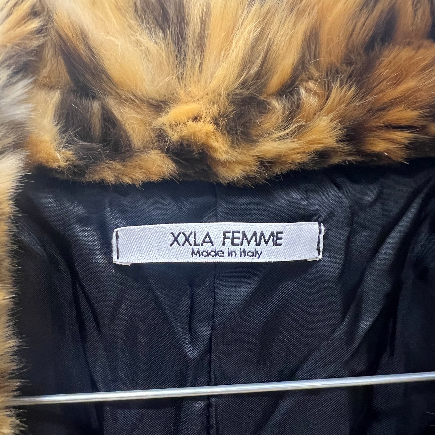 Black coat with fur hood and XXLA FEMME label on a hanger