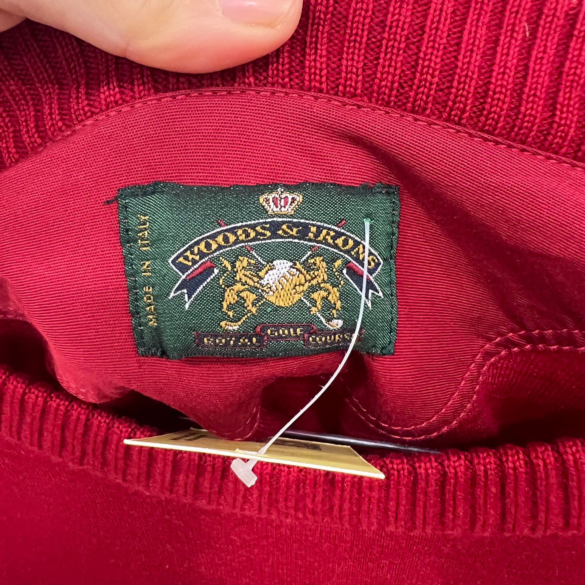 Close-up of a red garment with a visible label on a plain background