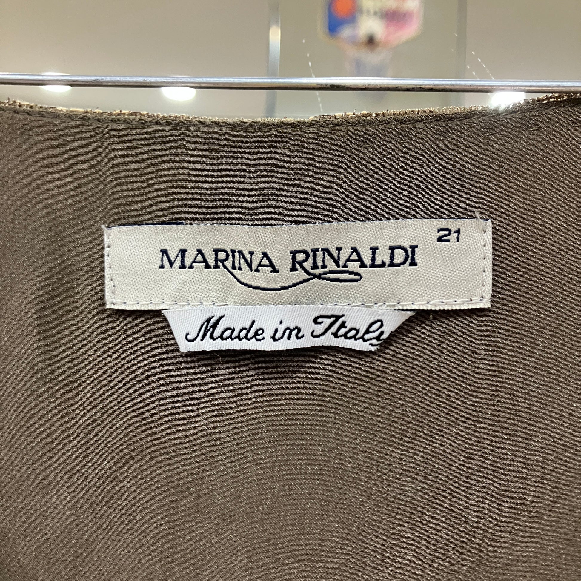 Marina Rinaldi label on a brown fabric background