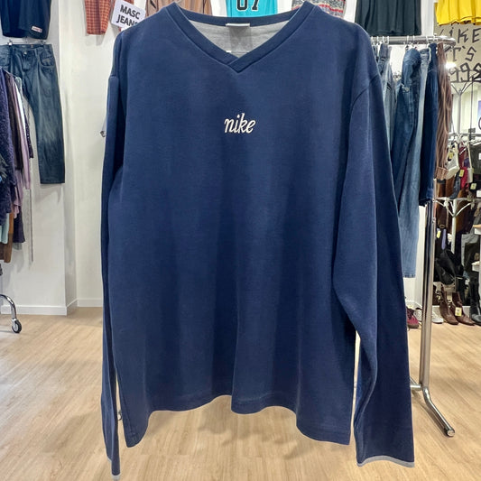 Navy blue Nike sweatshirt in a store setting with clothing racks in the background