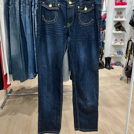 Pair of blue jeans displayed in a store setting with other clothing items in the background