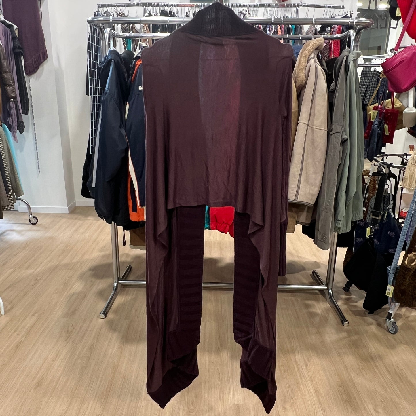 Brown outfit on a hanger in a clothing store with racks of clothes in the background