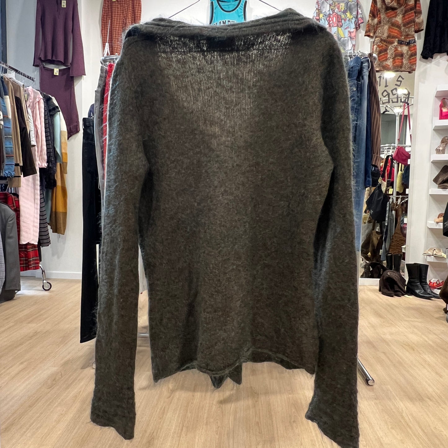 Dark gray sweater on a hanger in a clothing store