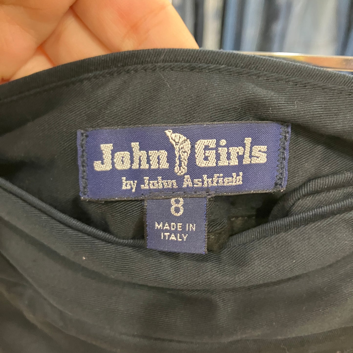 Label on a black garment with 'John Girls by John Ashfield' branding