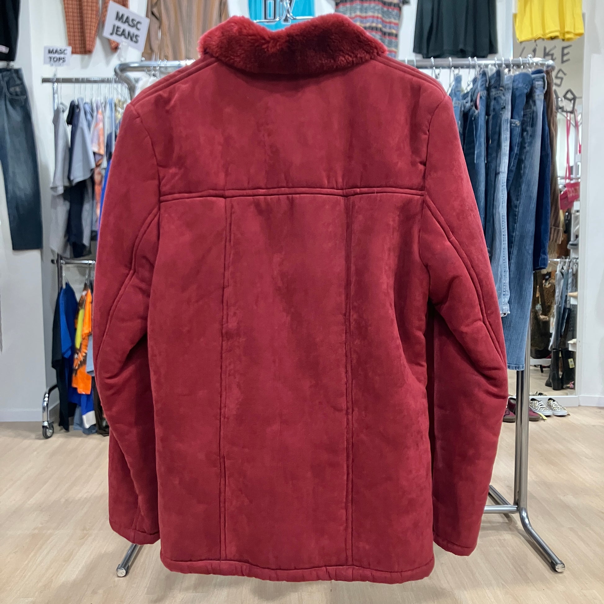 Red jacket with fur collar in a clothing store setting