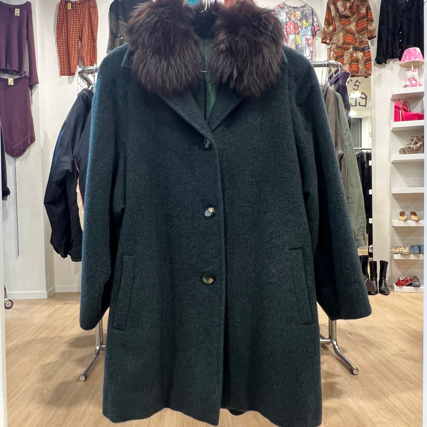 Dark green coat with fur collar in a clothing store