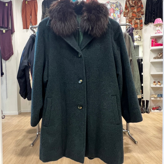 Dark green coat with fur collar in a clothing store