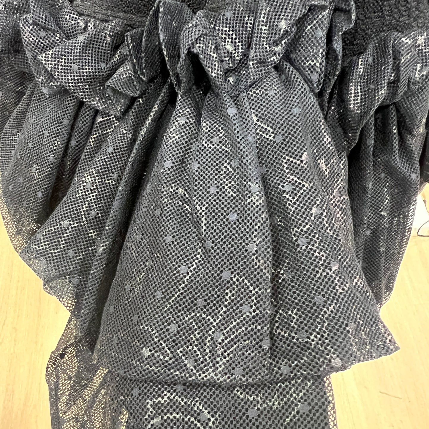 Close-up of a textured gray fabric with a pattern on a wooden surface