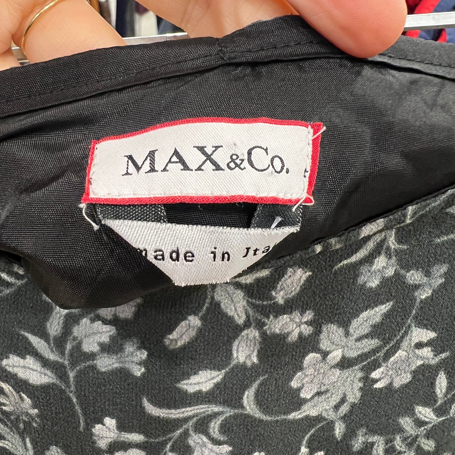 Close-up of a 'MAX&Co.' label on a floral-patterned fabric