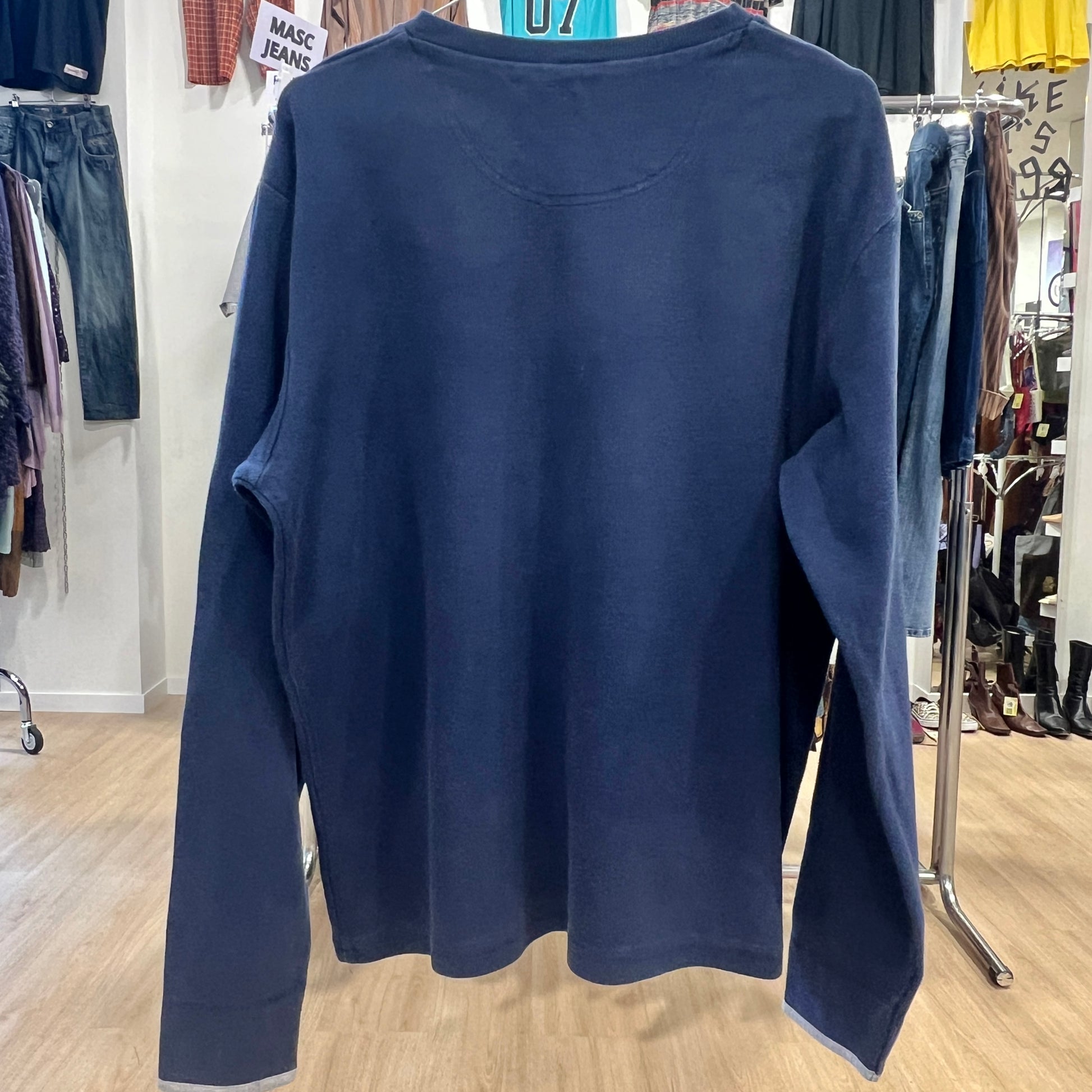 Navy blue sweatshirt on a hanger in a clothing store