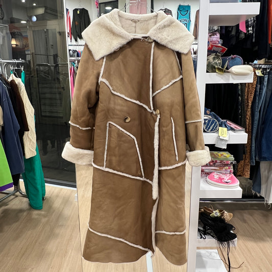 Brown coat with white fur trim in a store setting