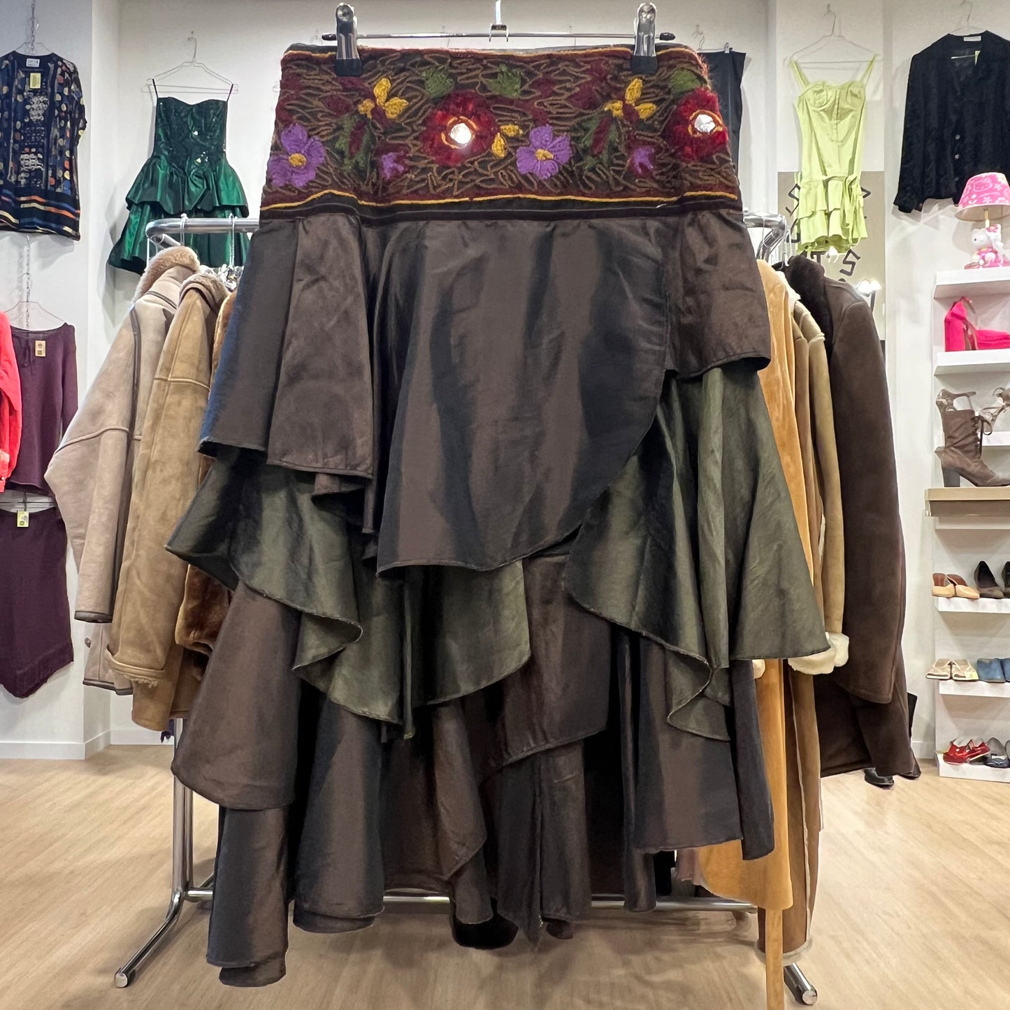 Dark brown layered skirt with floral embroidery on a clothing rack in a store