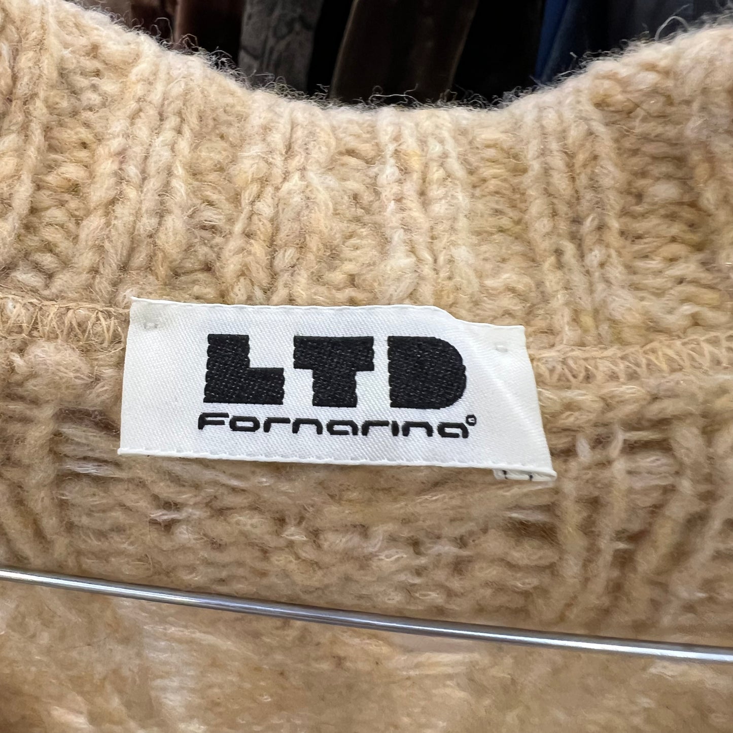 Close-up of a beige knitted fabric with an LTD Fornarina label