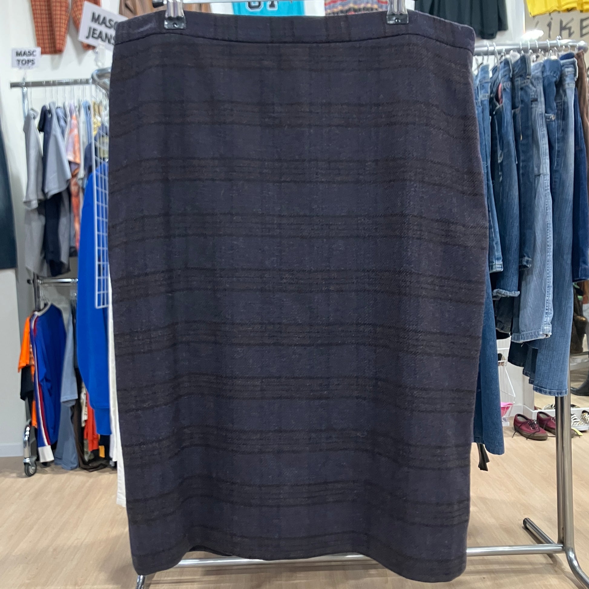 Dark skirt on a clothing rack in a store setting