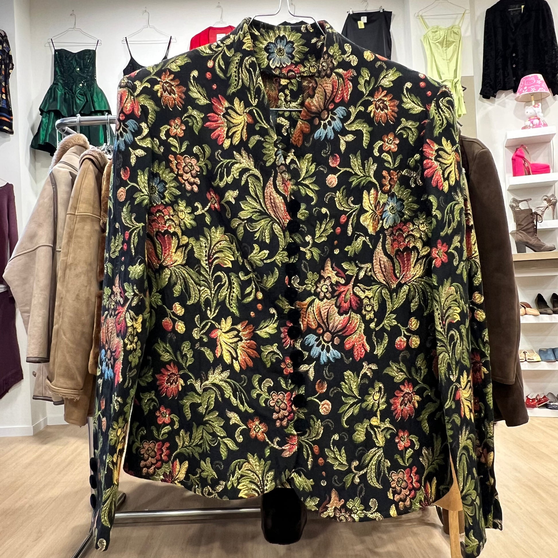 Floral patterned blazer on a rack in a store setting with other clothing items