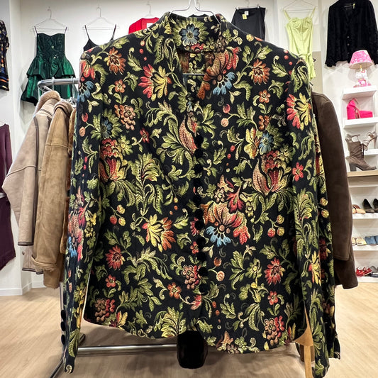 Floral patterned blazer on a rack in a store setting with other clothing items