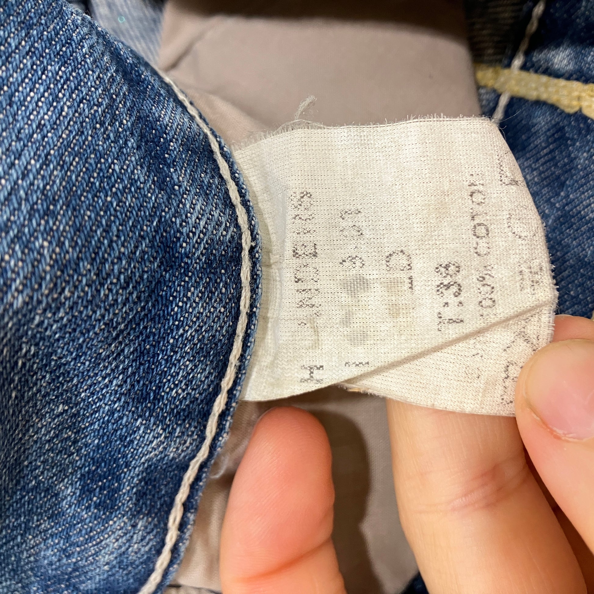 Close-up of a denim fabric label with text and numbers