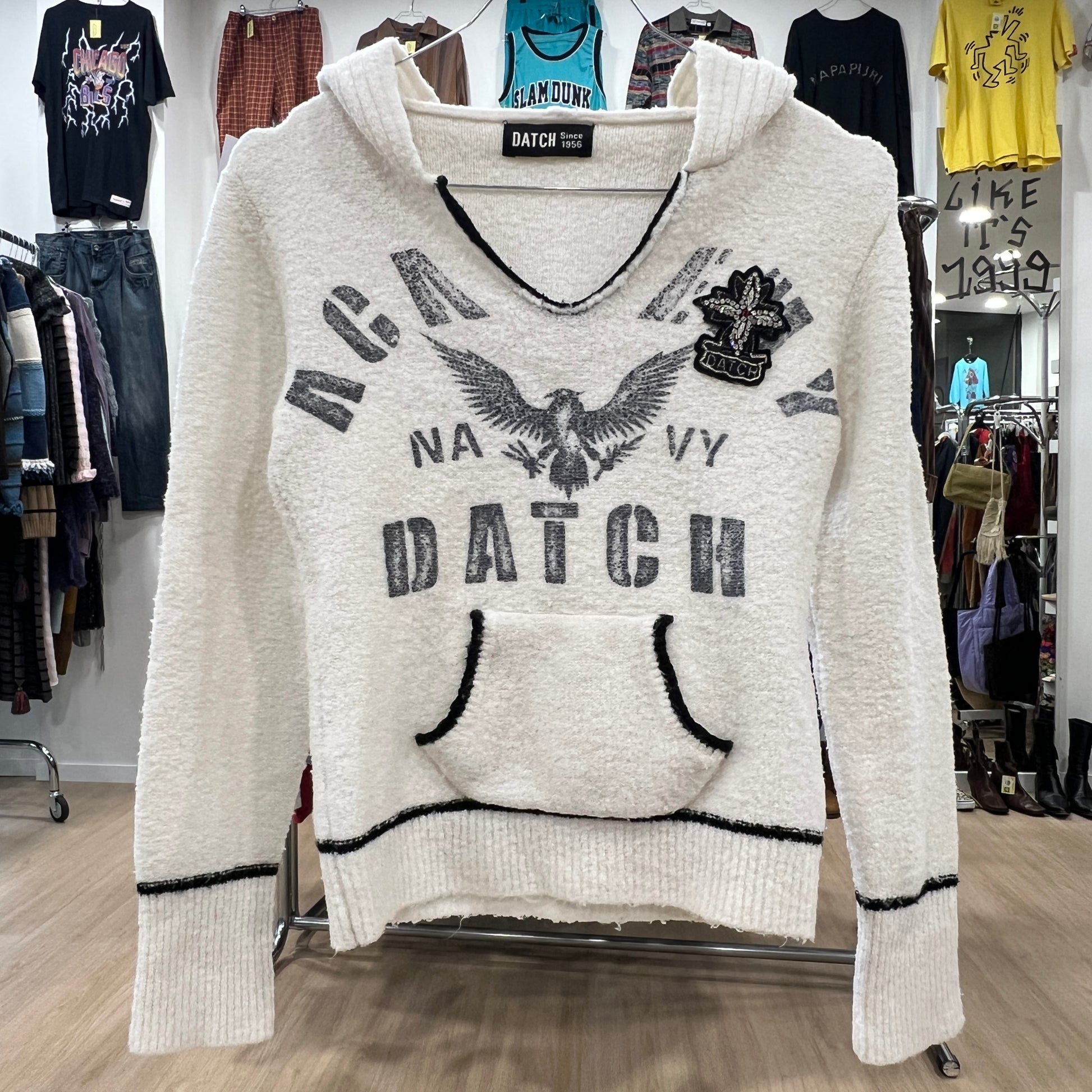 White hoodie with 'Navy Datch' text and eagle design in a clothing store
