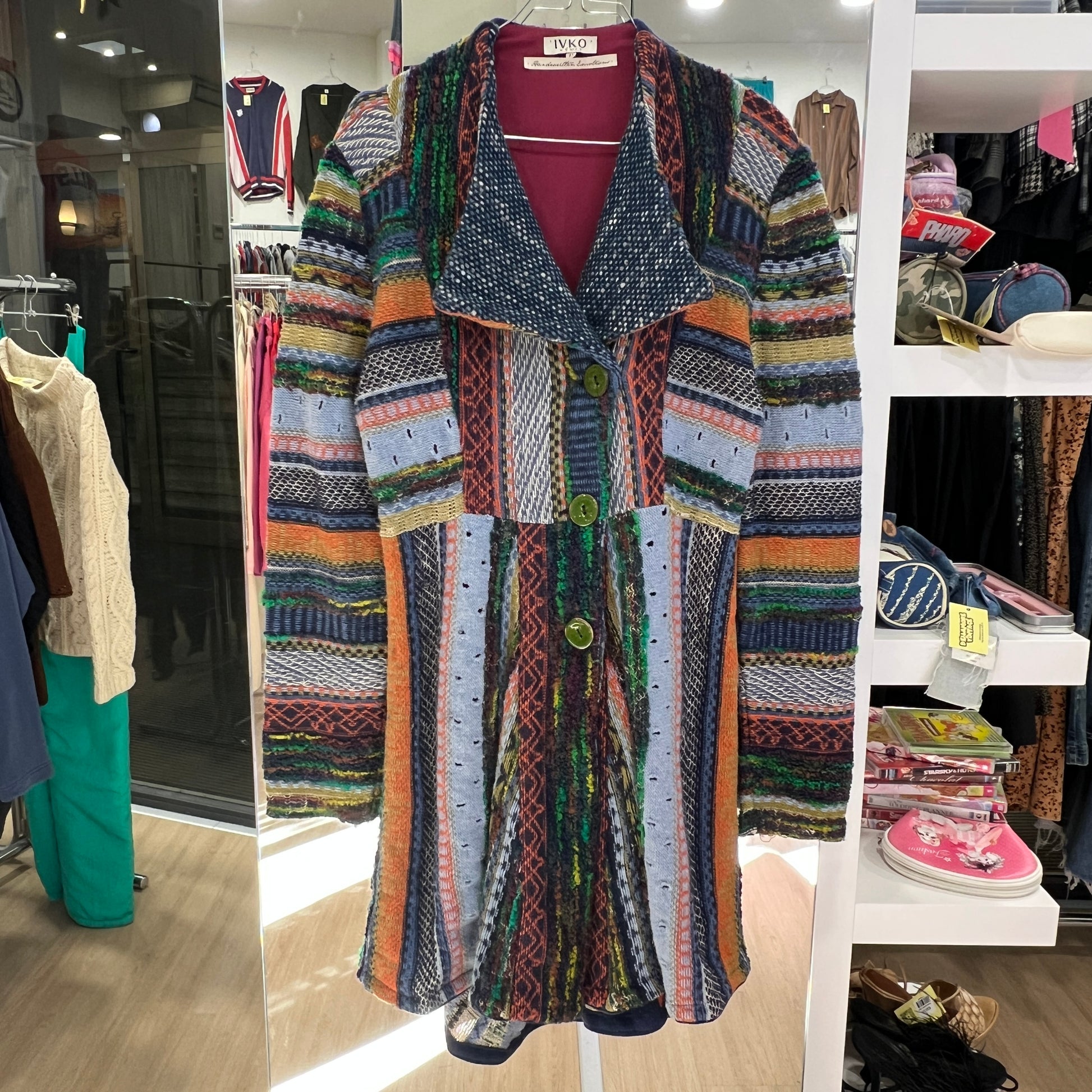 Multicolored patterned cardigan displayed in a store setting