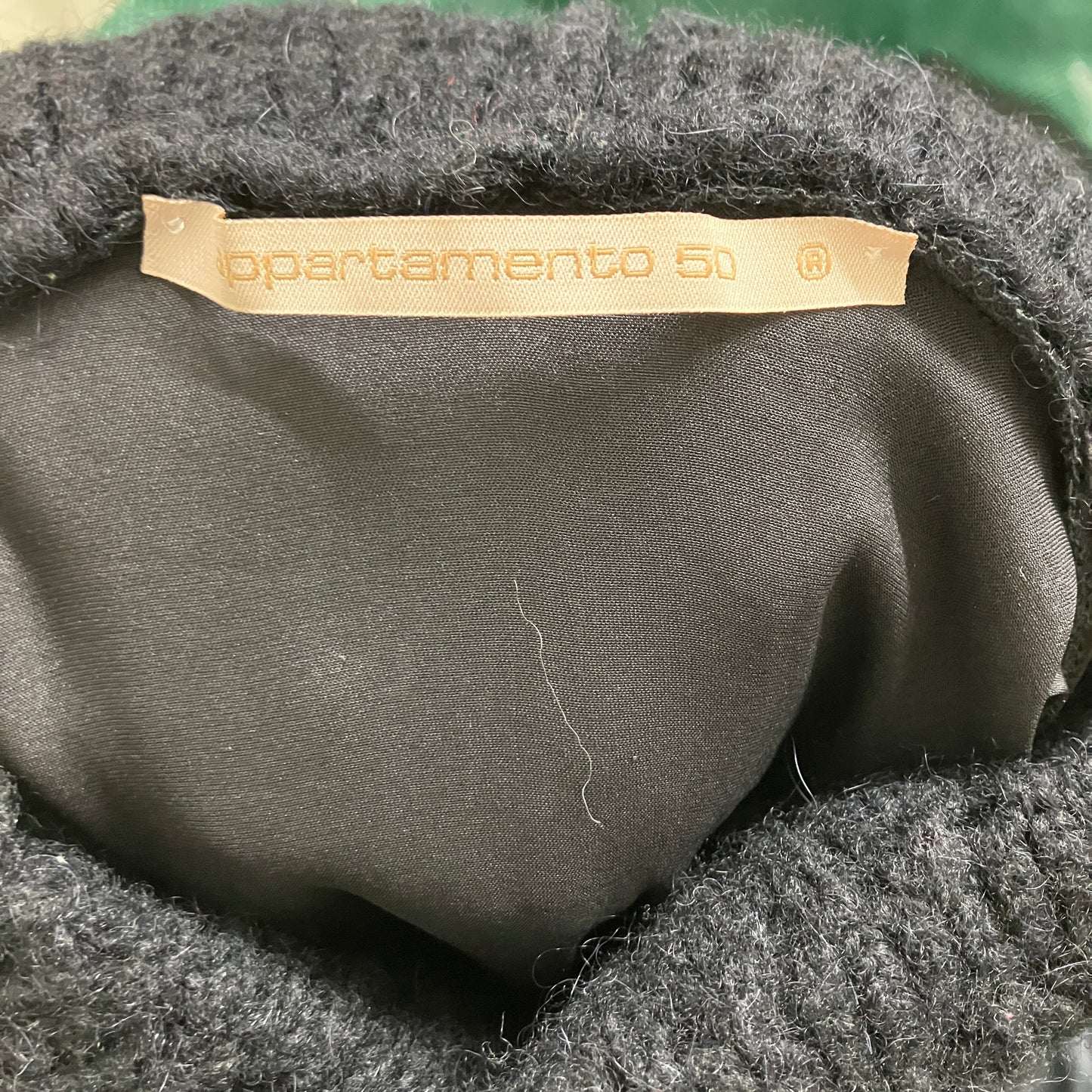 Close-up of a black fabric item with 'apartamento 50' label
