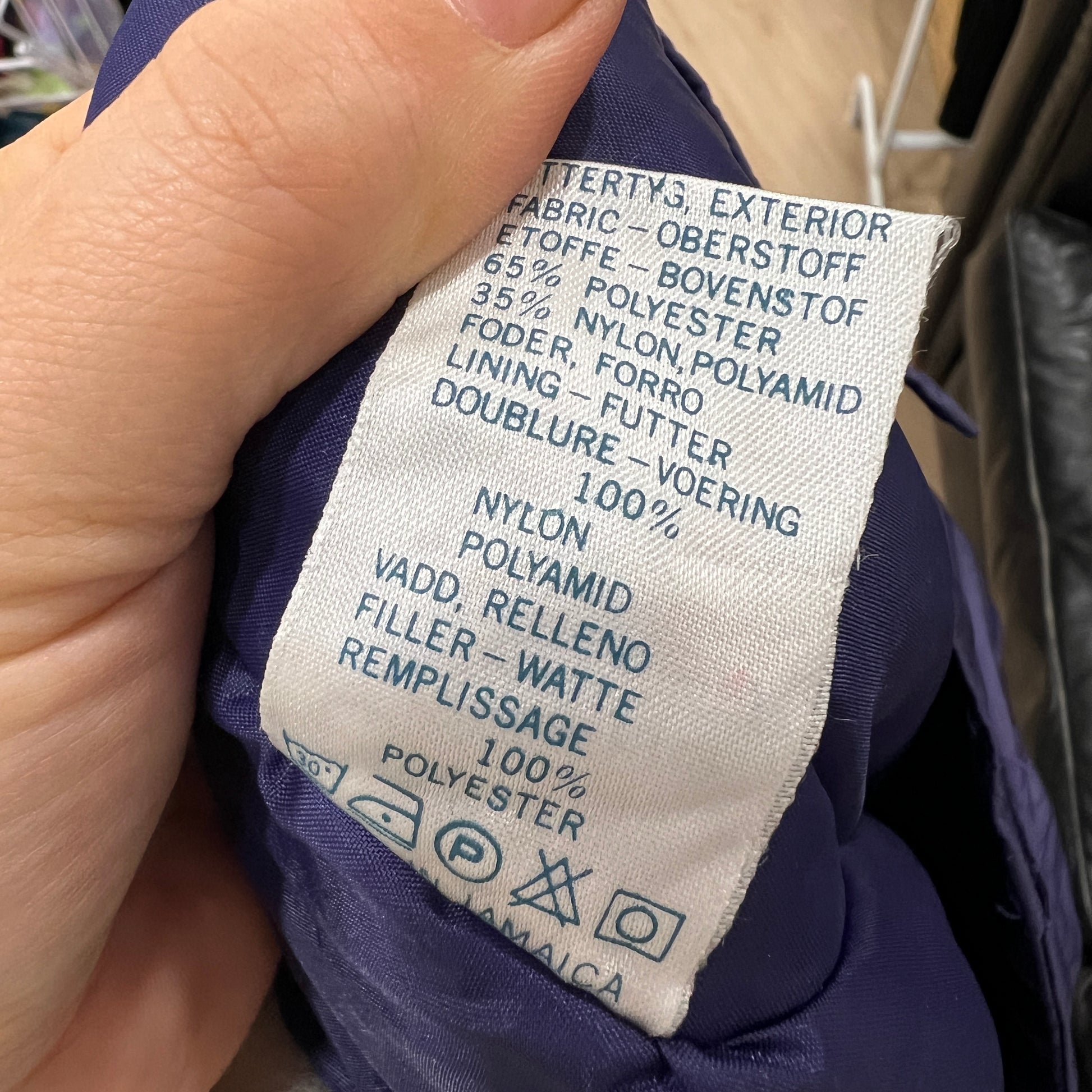 Clothing label with fabric composition details held by a hand