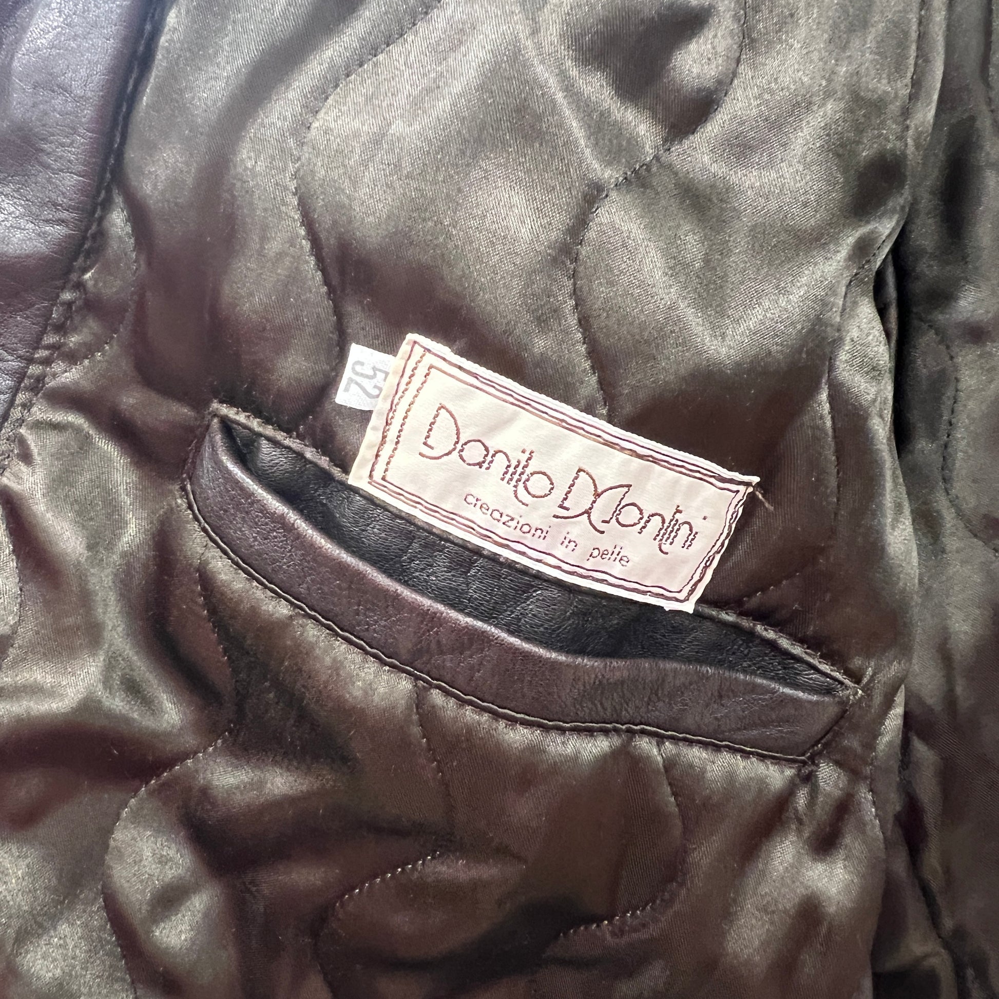 Close-up of a leather jacket with a brand label on a dark background
