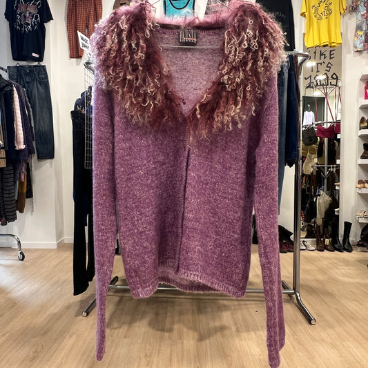 Purple sweater with curly sleeves on a rack in a store setting