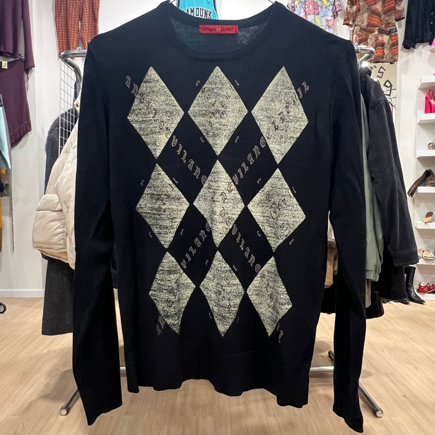 Black sweater with diamond pattern in a store setting