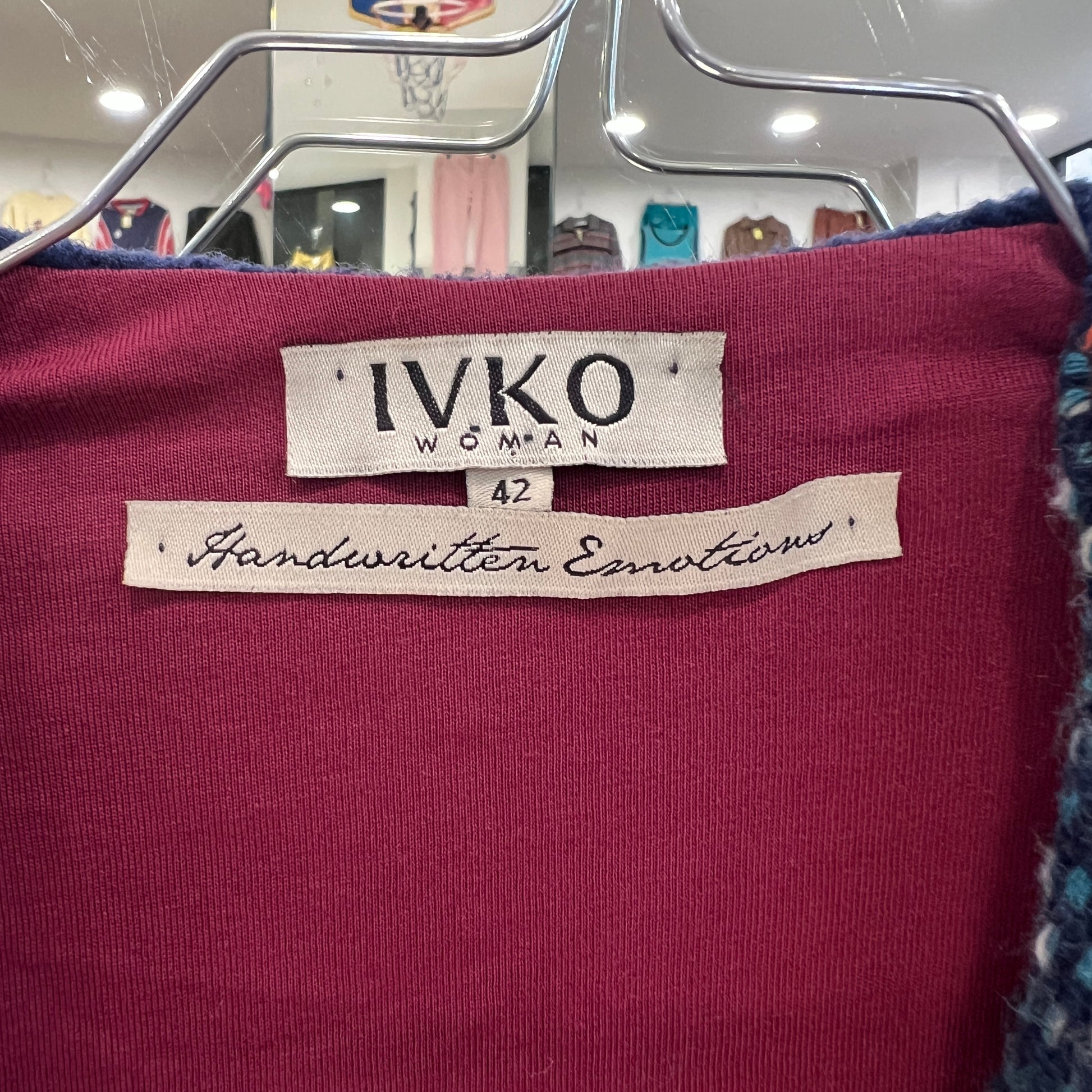 Maroon garment with IVKO label on a hanger