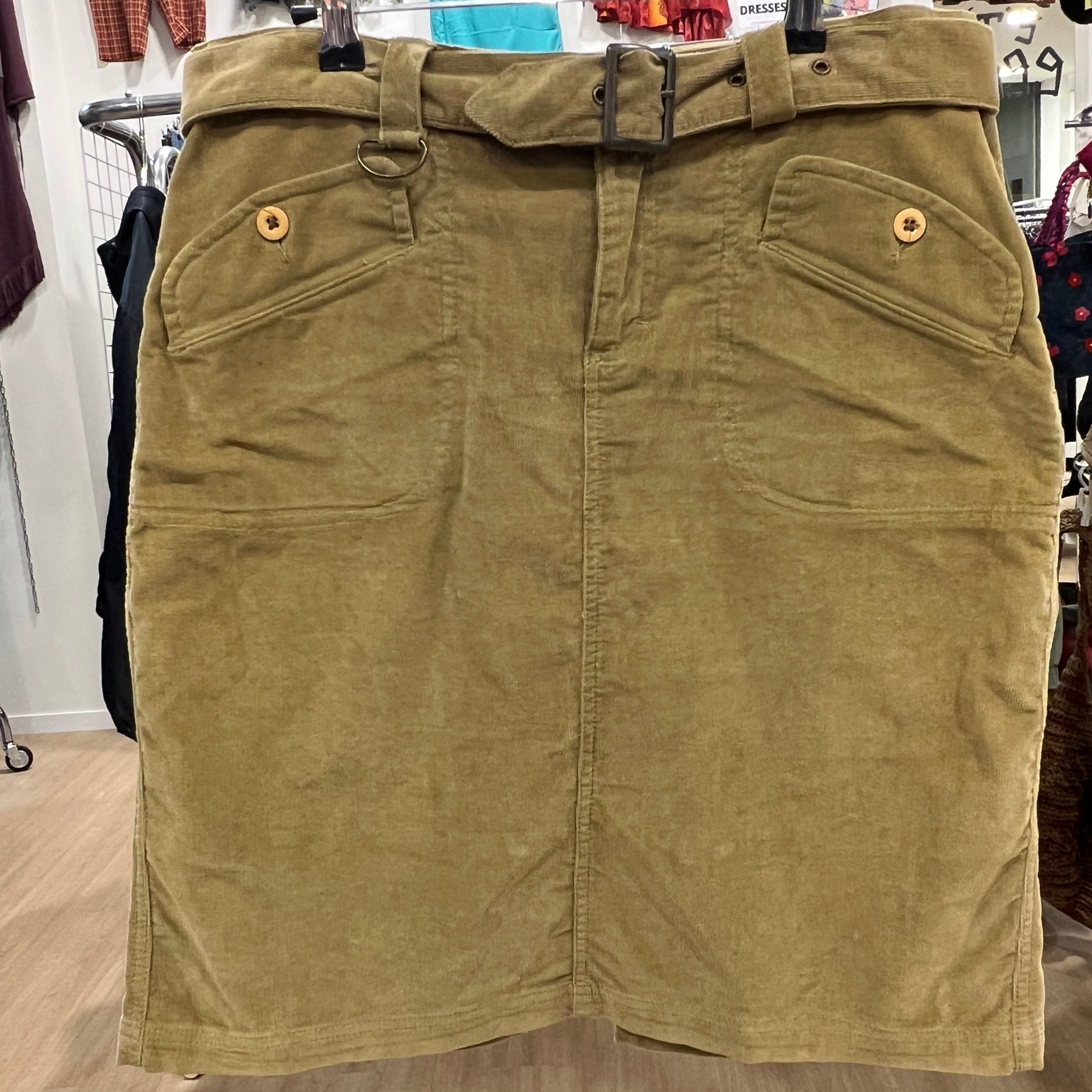 Camel skirt on a hanger with a blurred store background