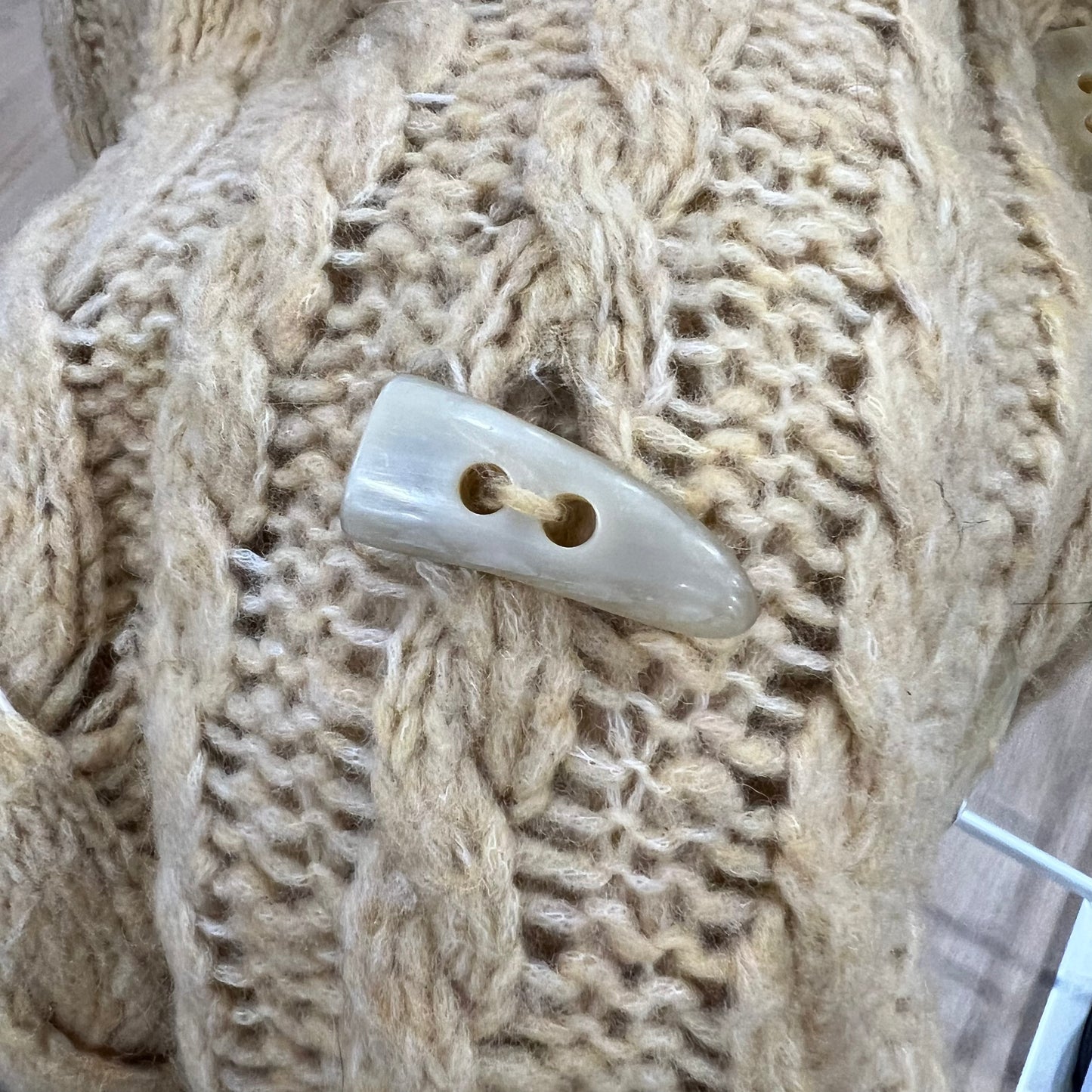 Close-up of a button on a knitted fabric background