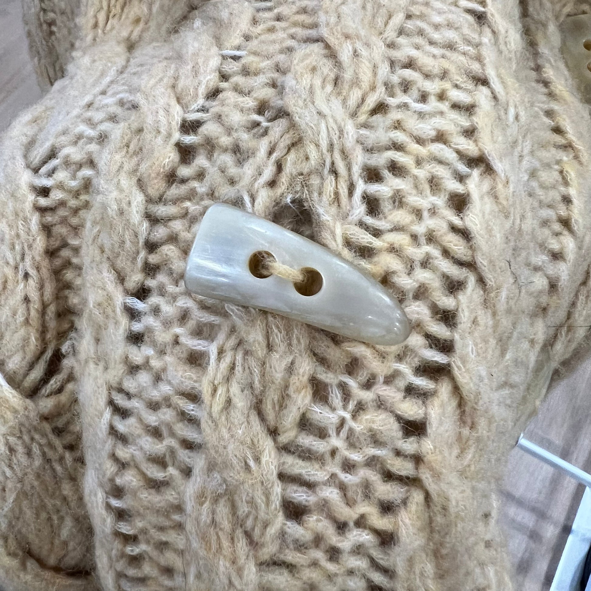 Close-up of a button on a knitted fabric background